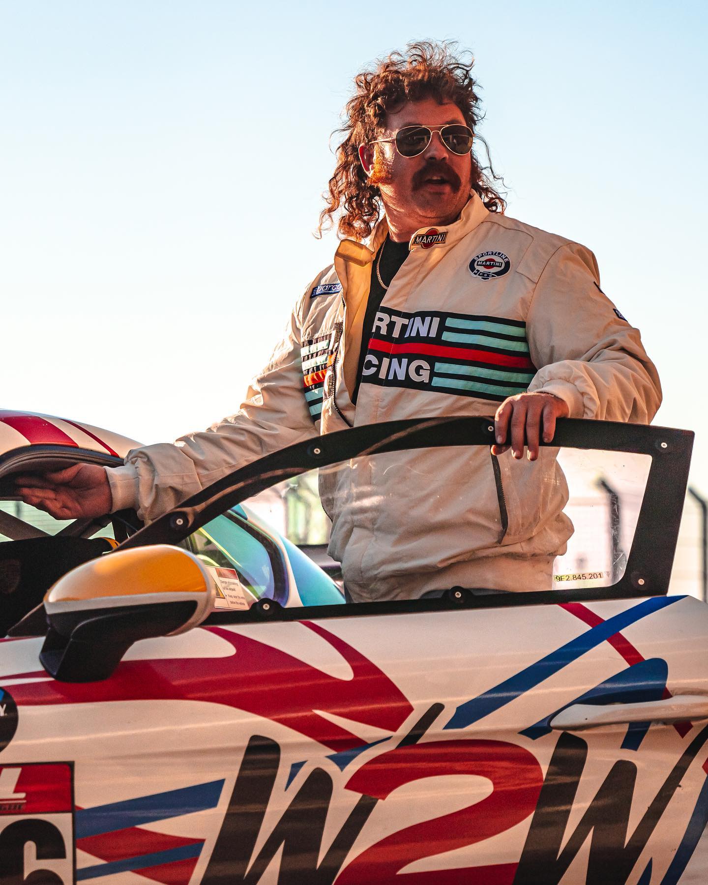 Dean Stanfield in racing gear by his race car
